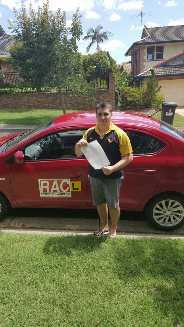 Learner beside a red RAC driving-school car